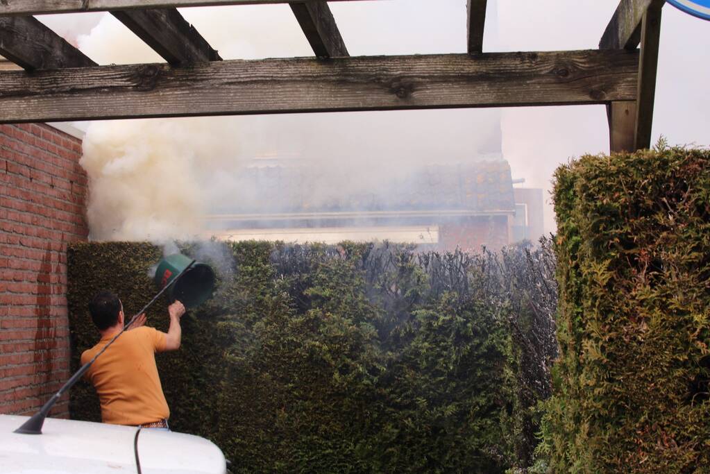 Brandweer blust brandende coniferenhaag