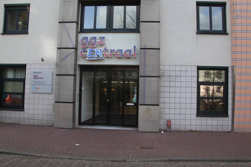 Verwarde vrouw met hond op het dak van GGZ-kantoor