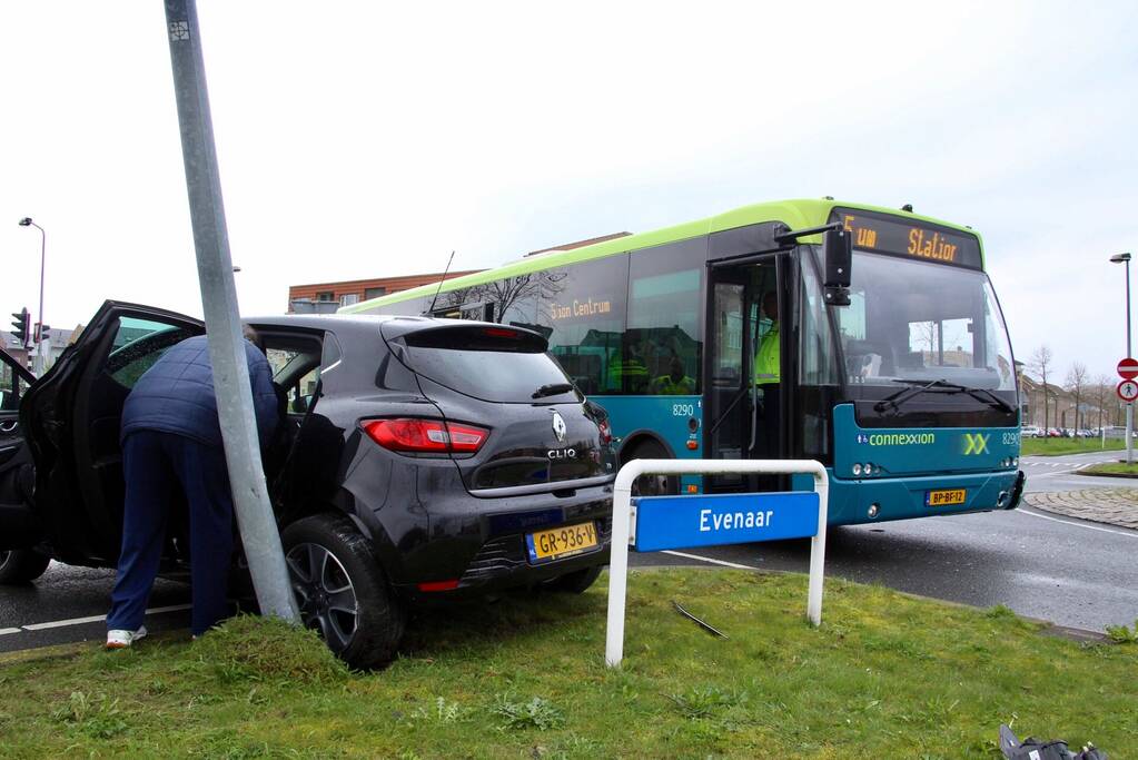 Stadsbus rijdt auto tegen lantaarnpaal
