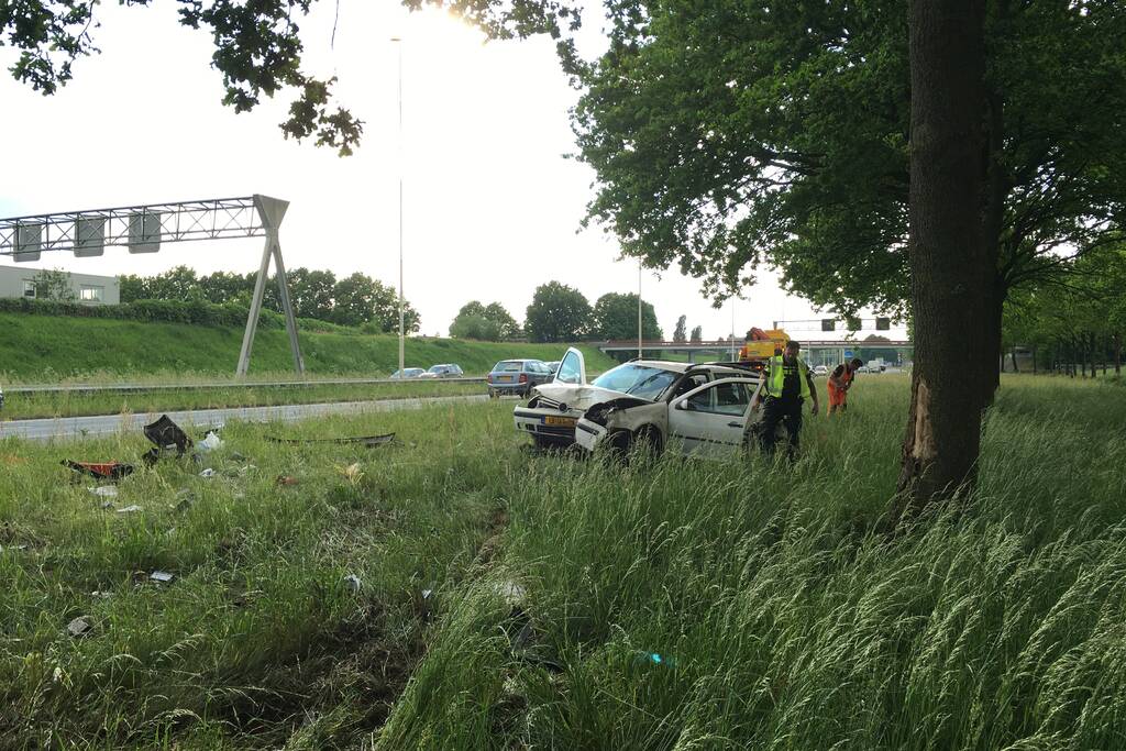 Auto raakt van de weg en knalt tegen boom