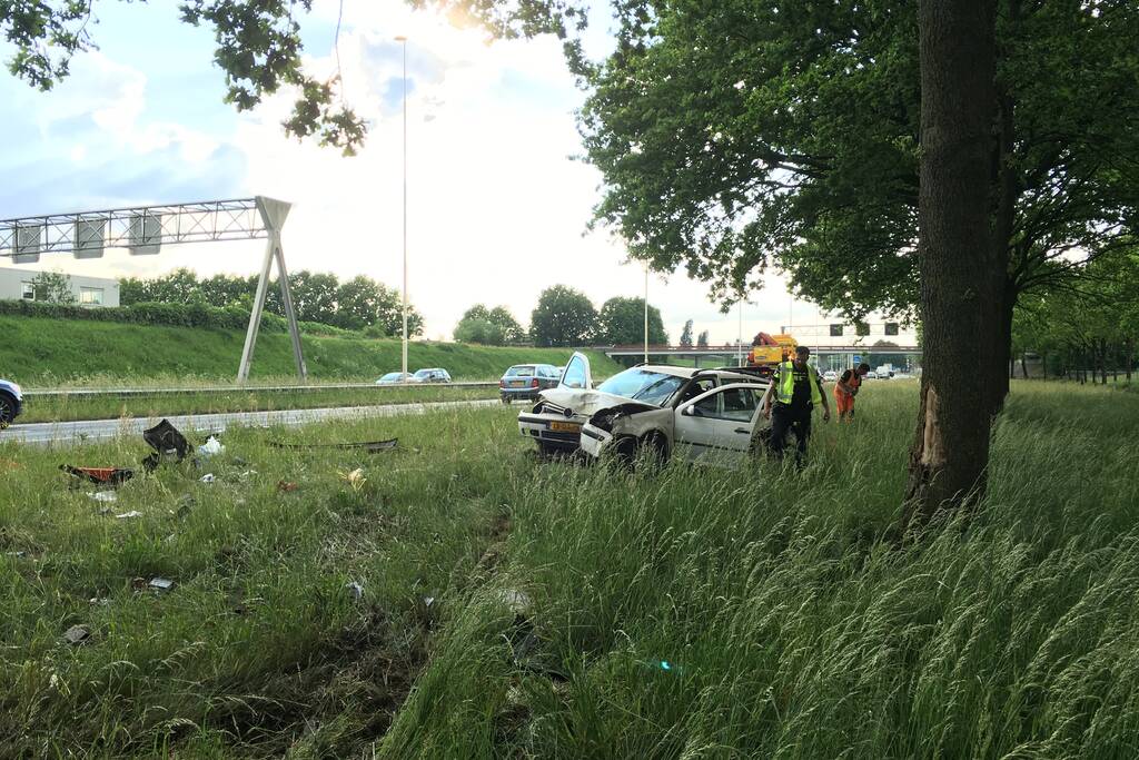 Auto raakt van de weg en knalt tegen boom