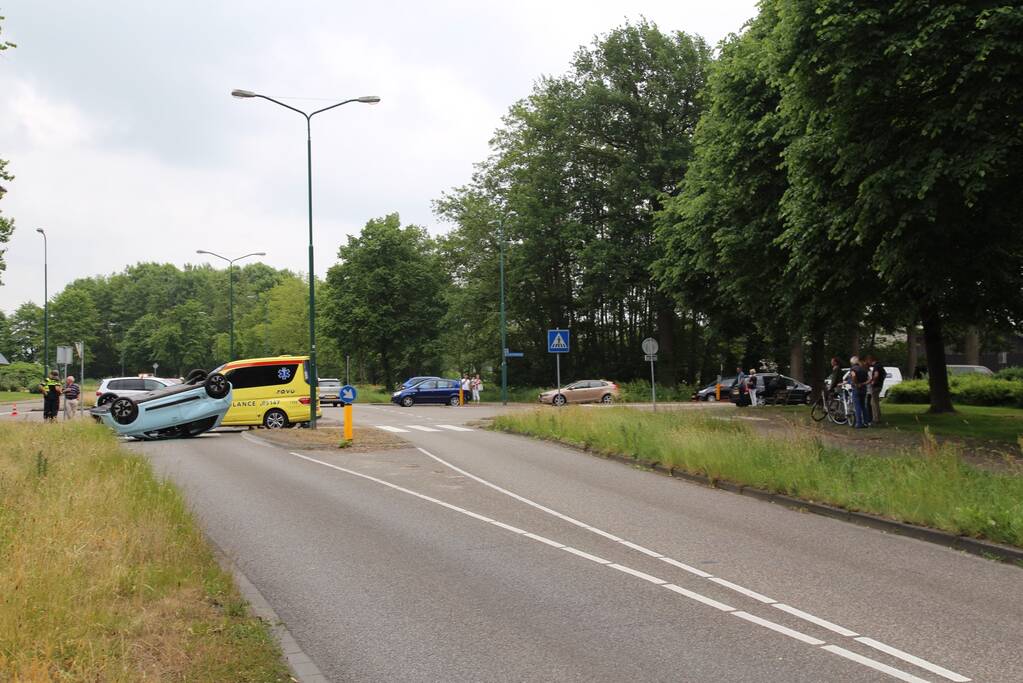 Auto over de kop na botsing