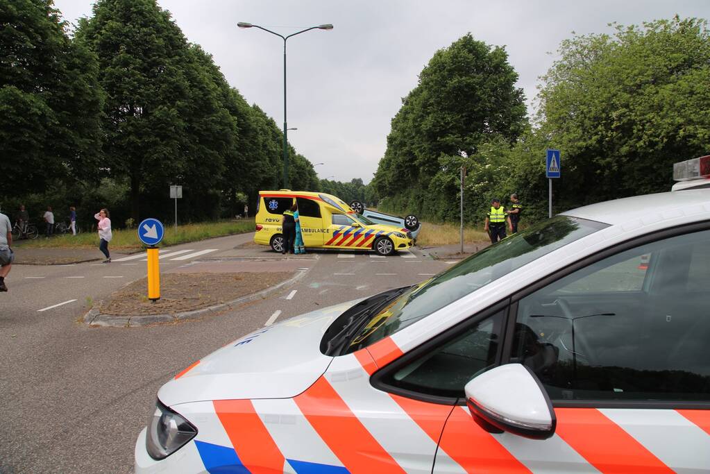 Auto over de kop na botsing