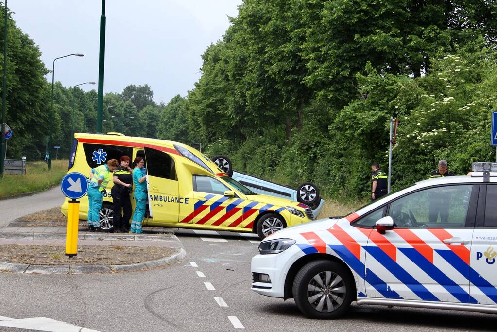 Auto over de kop na botsing
