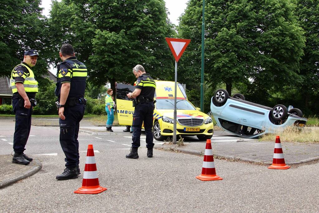 Auto over de kop na botsing