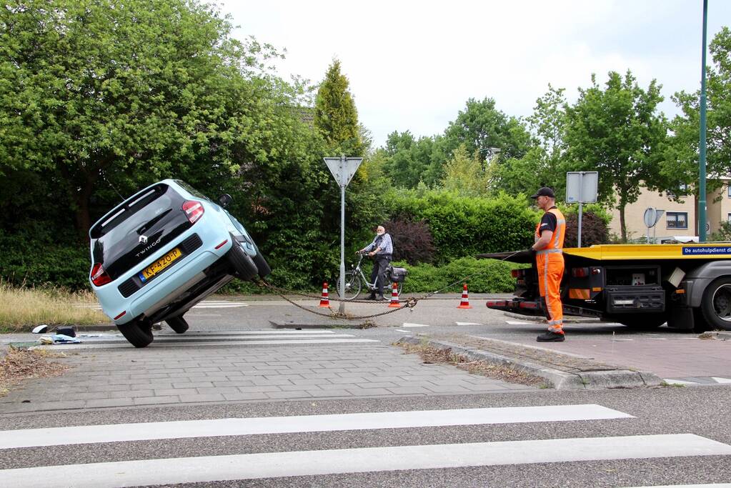 Auto over de kop na botsing