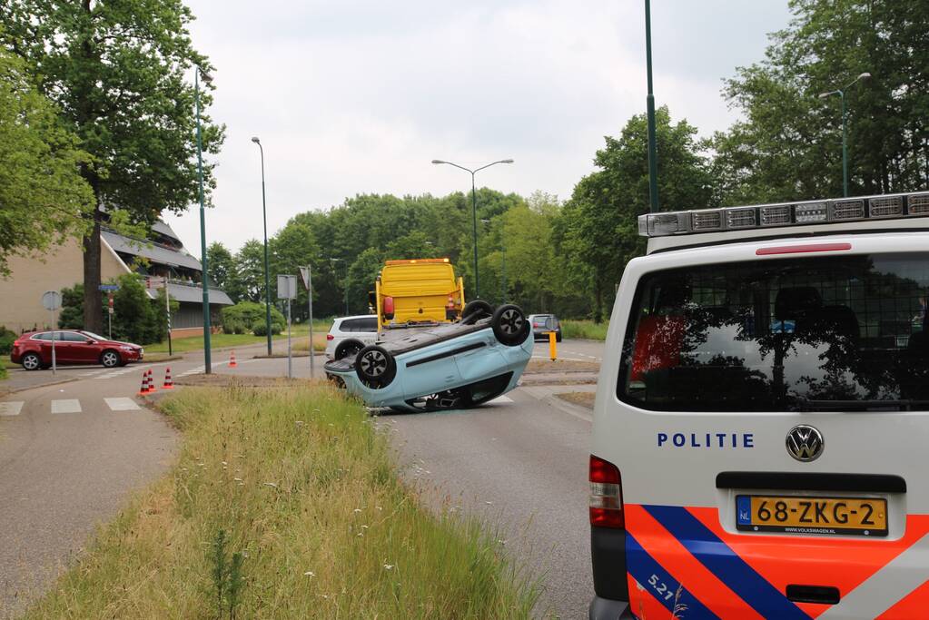 Auto over de kop na botsing