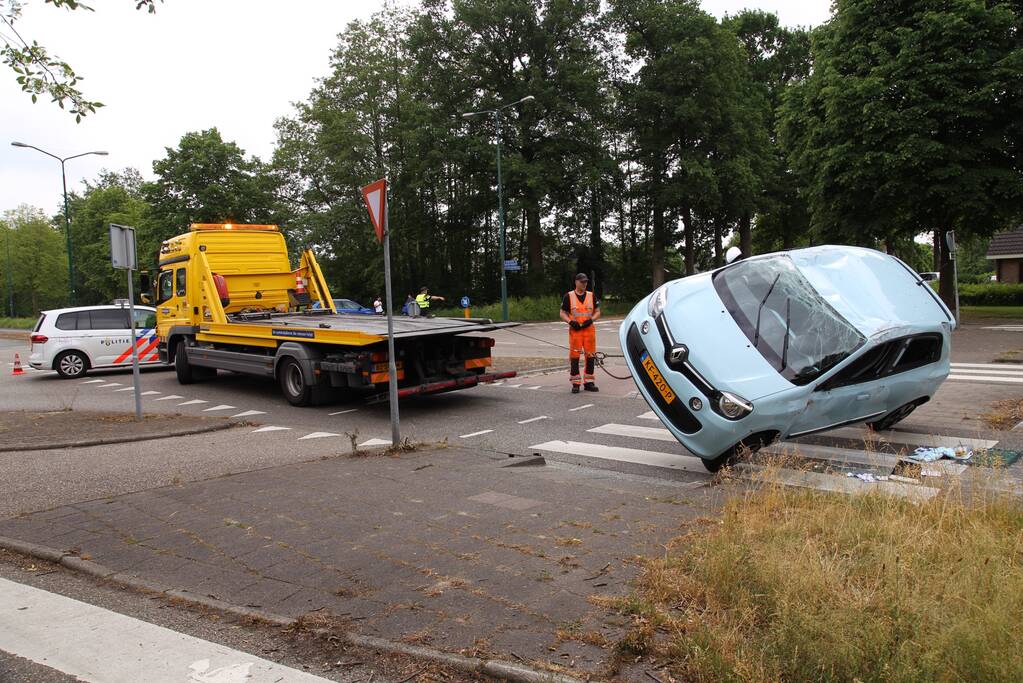 Auto over de kop na botsing
