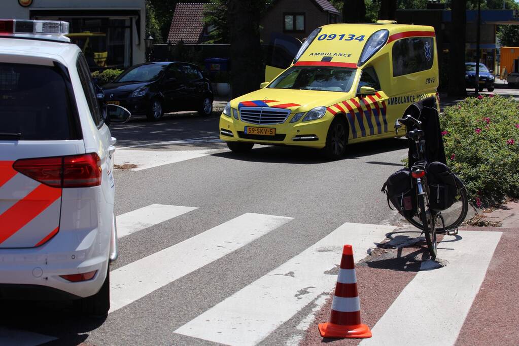 Fietser geschept door auto op rotonde
