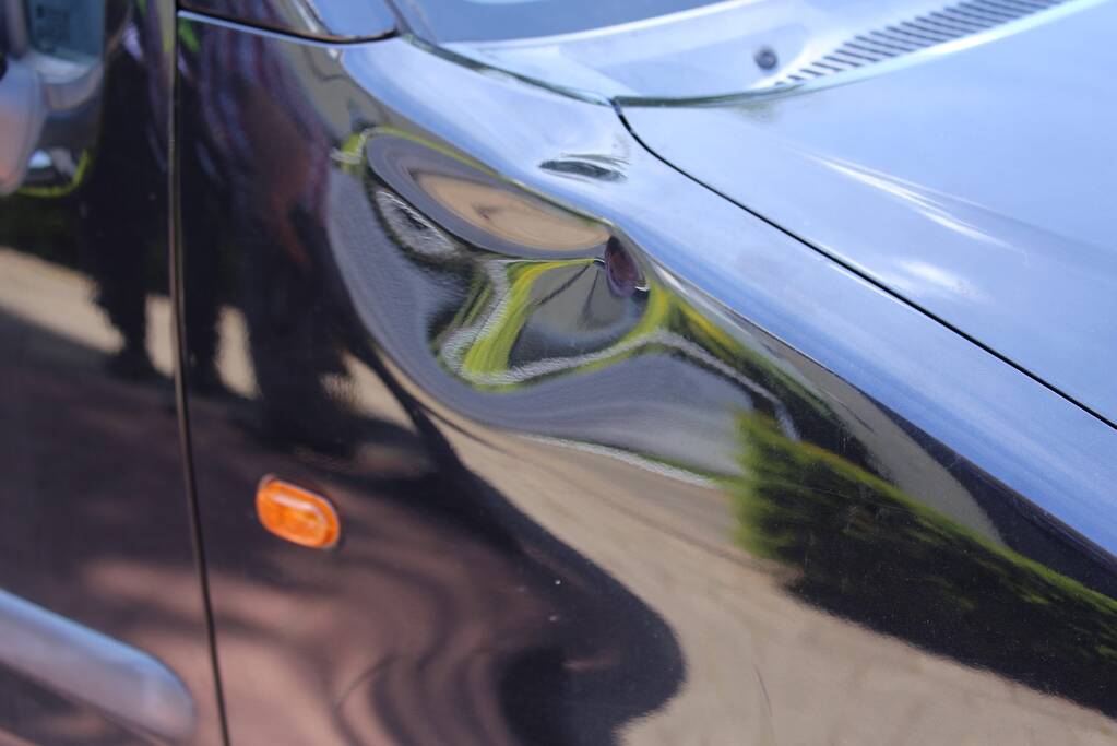 Fietser geschept door auto op rotonde