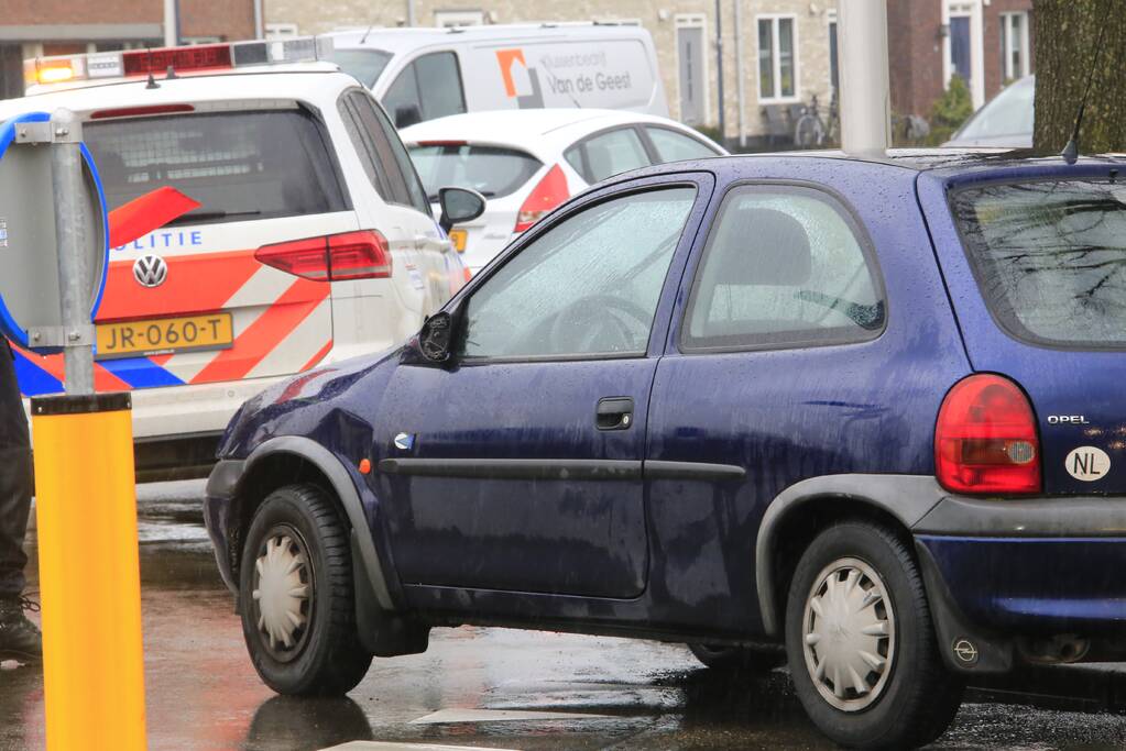 Auto en scooter botsen op rotonde
