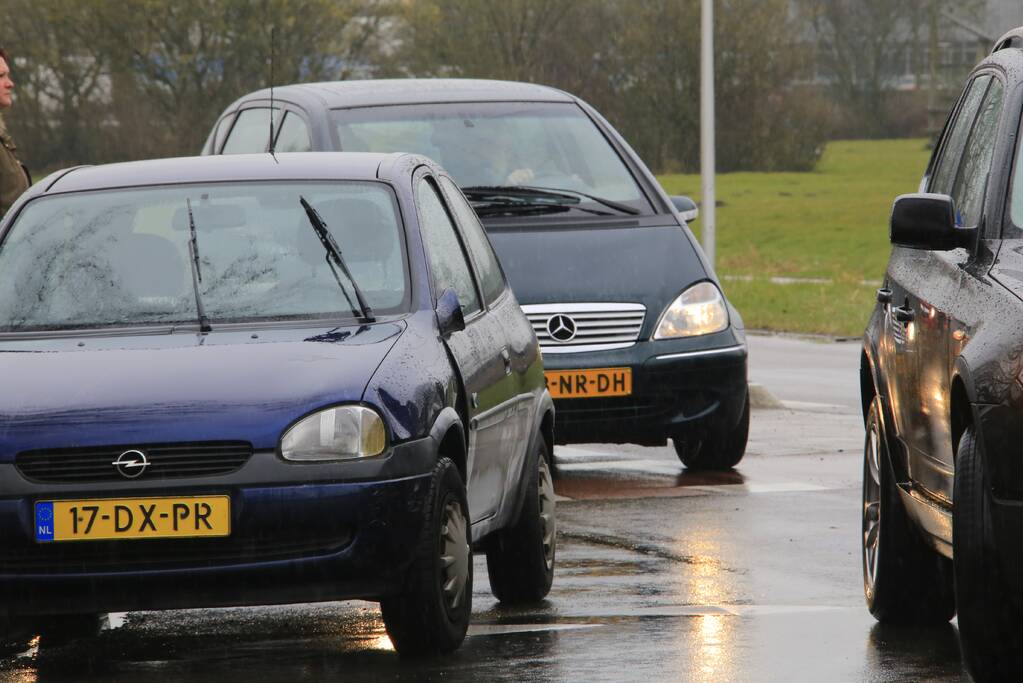 Auto en scooter botsen op rotonde