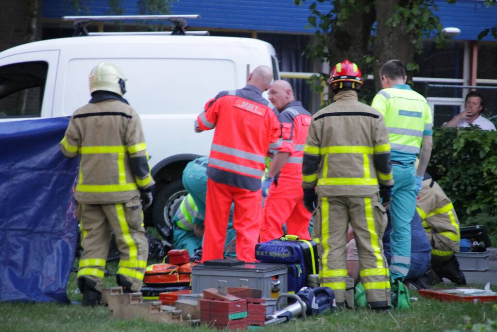 Persoon gewond onder bestelwagen