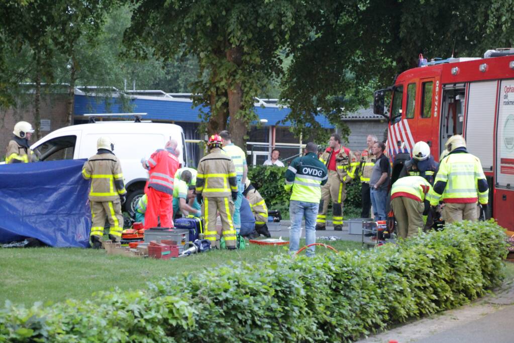 Persoon gewond onder bestelwagen