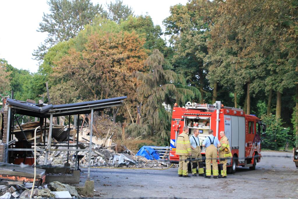Brandweer blust kleine brand in afgebrand pand