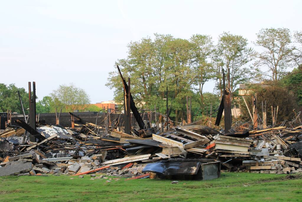 Brandweer blust kleine brand in afgebrand pand
