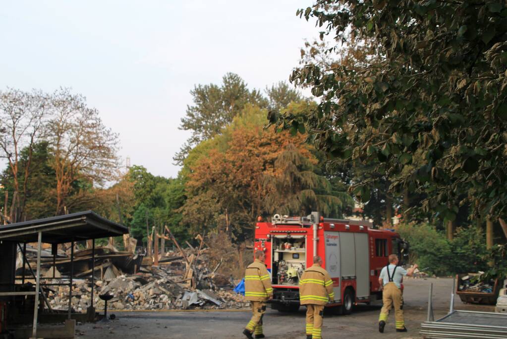 Brandweer blust kleine brand in afgebrand pand