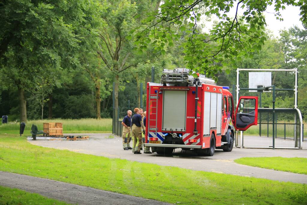 Brandweer blust aangestoken pallets
