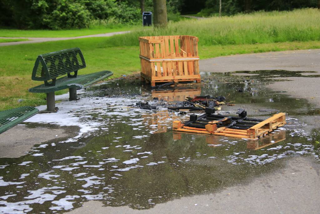 Brandweer blust aangestoken pallets