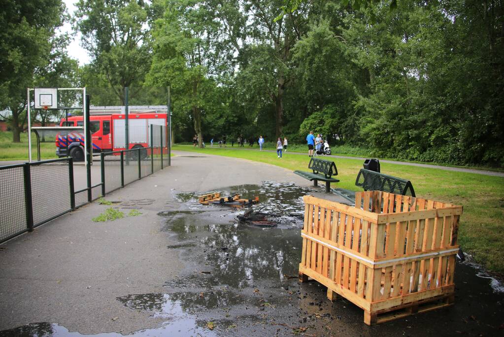 Brandweer blust aangestoken pallets
