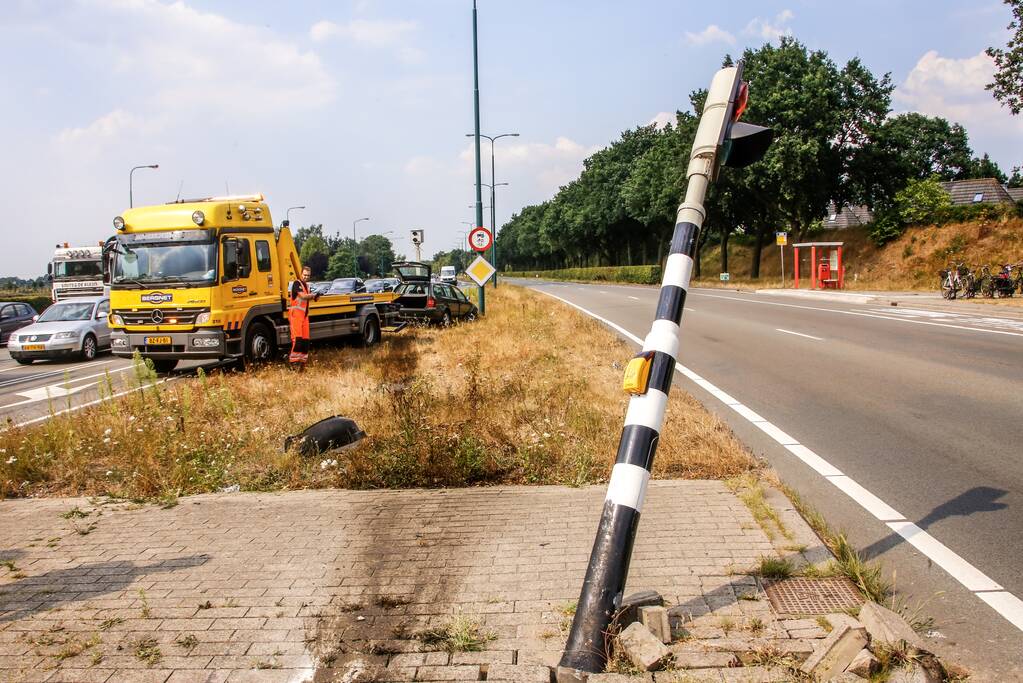 Automobilist vliegt over vluchtheuvel en ramt stoplicht