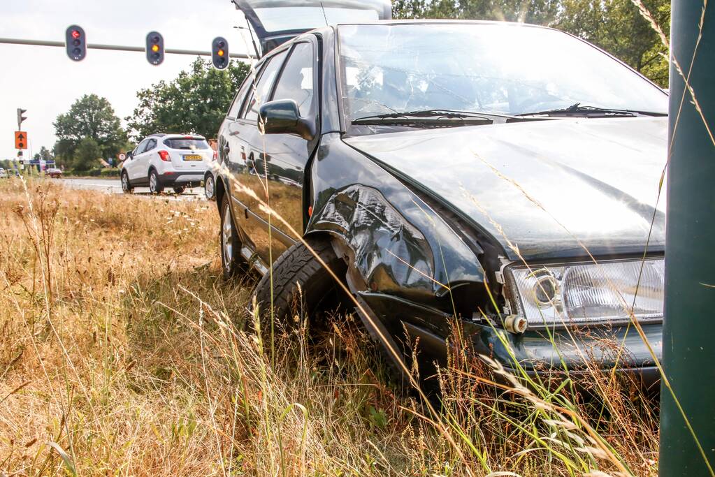 Automobilist vliegt over vluchtheuvel en ramt stoplicht