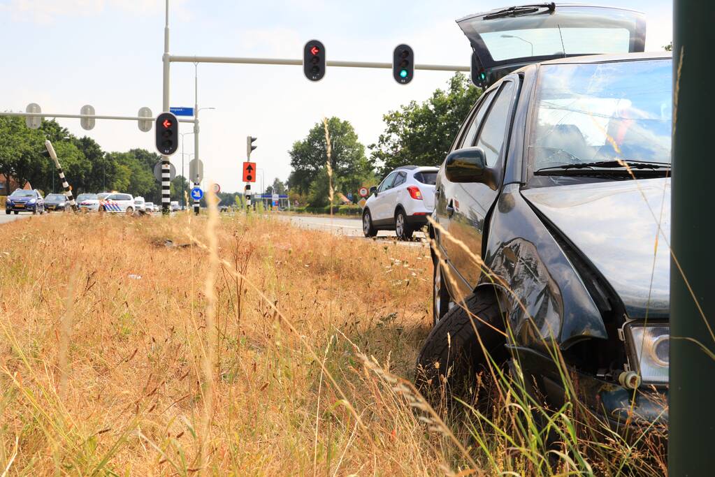 Automobilist vliegt over vluchtheuvel en ramt stoplicht