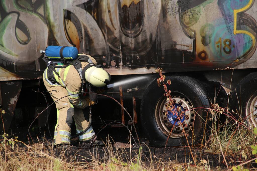 Brand nabij oude trailer in weiland