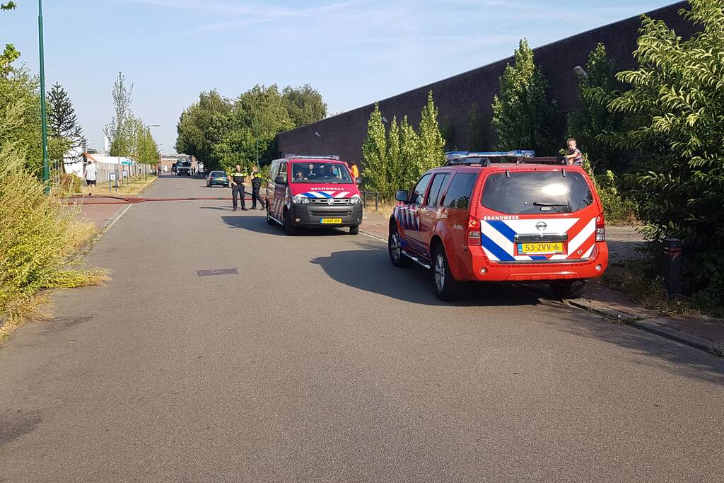 Brand nabij oude trailer in weiland