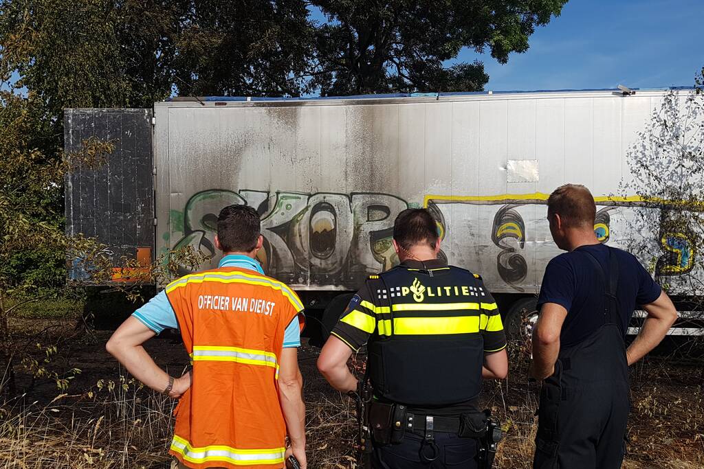 Brand nabij oude trailer in weiland