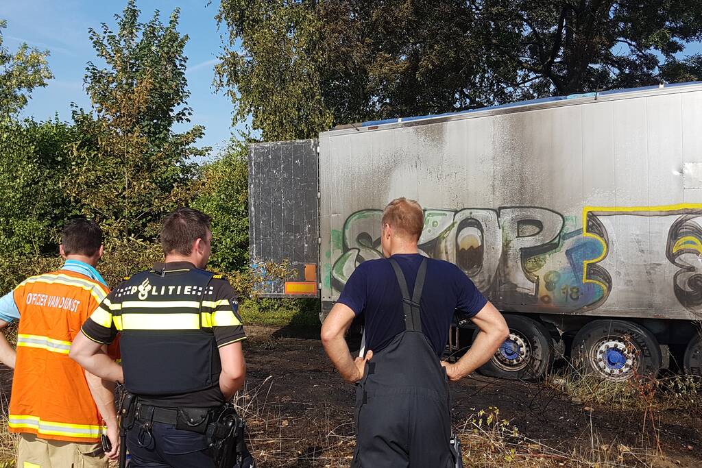 Brand nabij oude trailer in weiland
