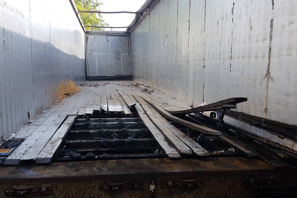 Brand nabij oude trailer in weiland