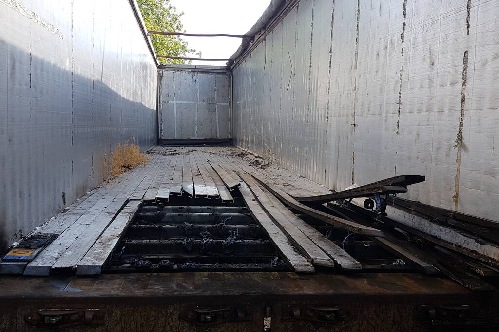 Brand nabij oude trailer in weiland