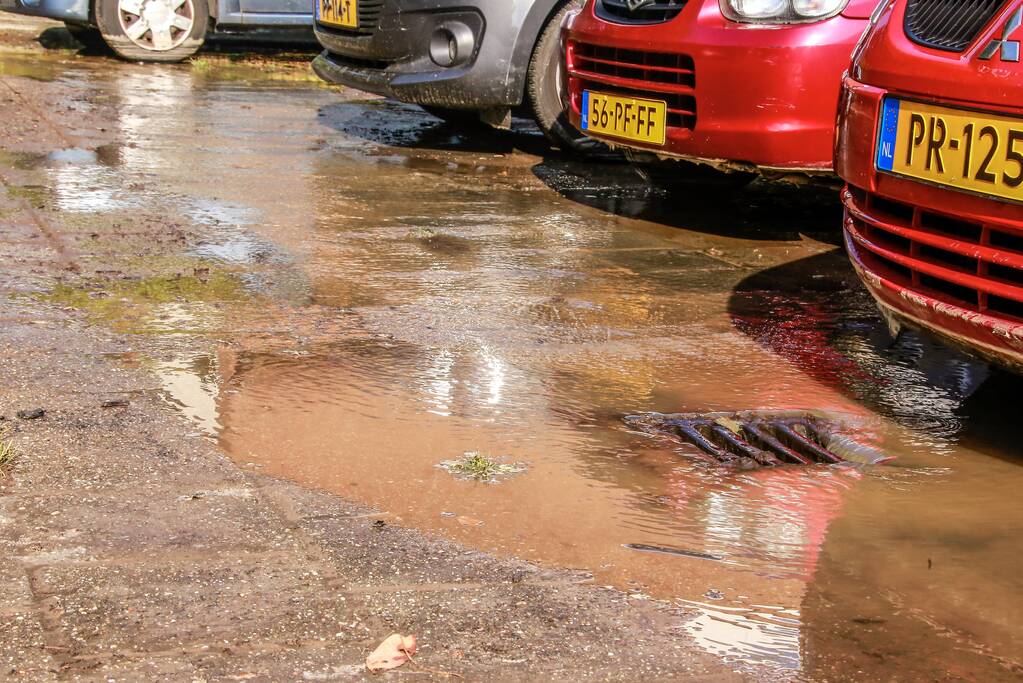 Parkeerplaatsen onder water door gesprongen waterleiding