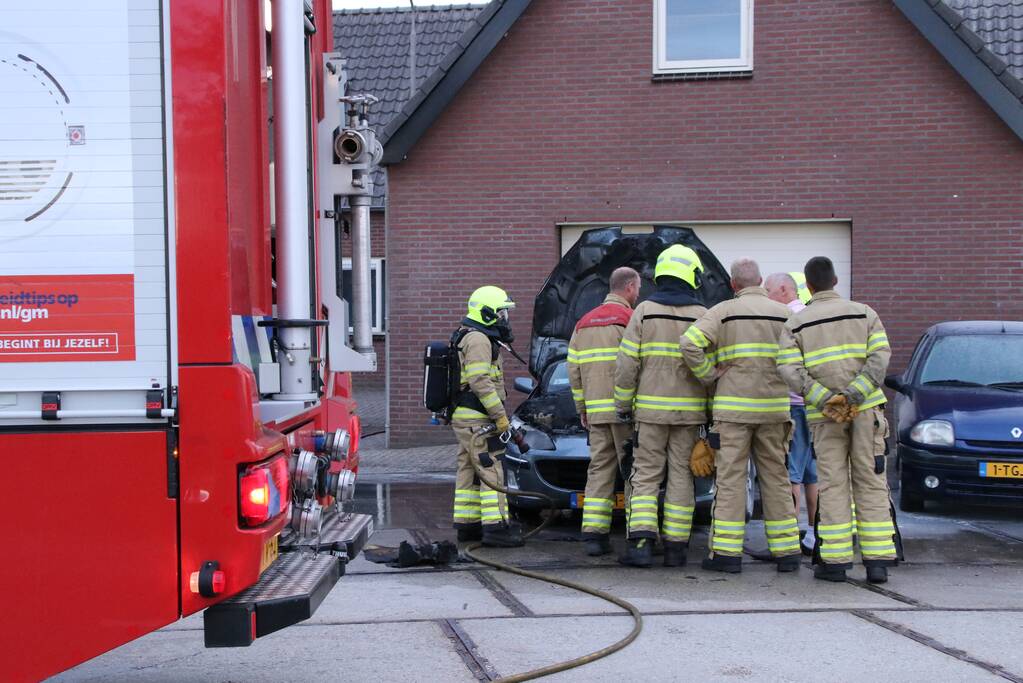 Auto vat vlam voor de garage
