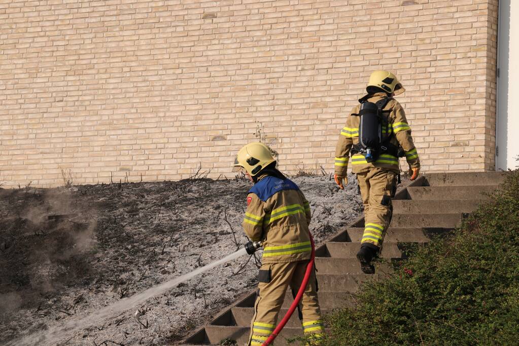 Groenstrook tegen sporthal in brand gestoken