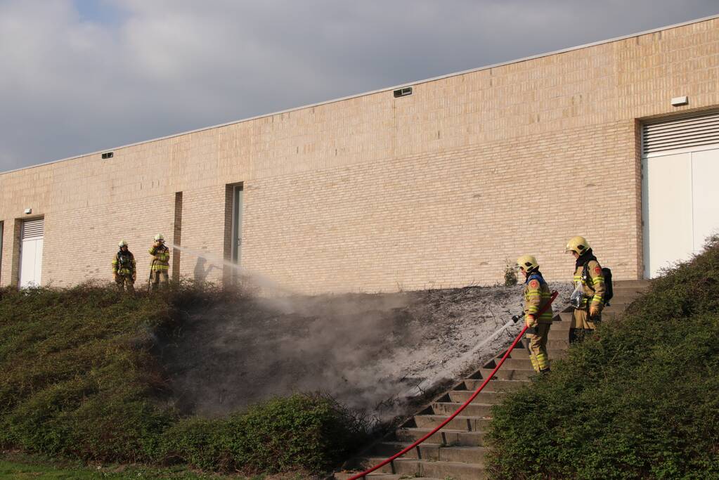 Groenstrook tegen sporthal in brand gestoken