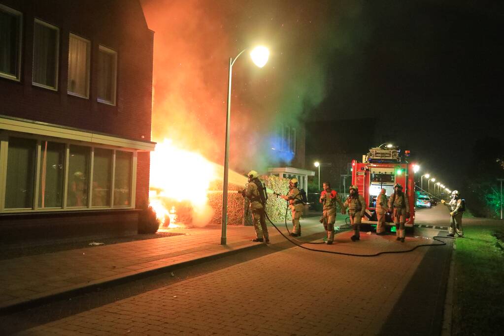 Auto in lichterlaaie onder carport van woning