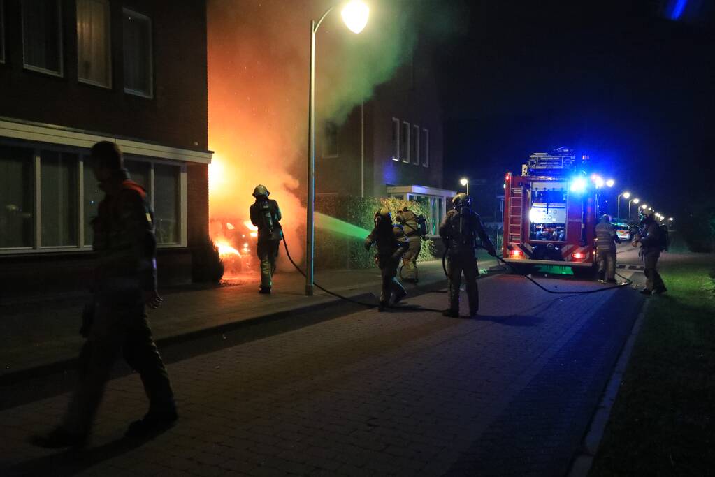 Auto in lichterlaaie onder carport van woning