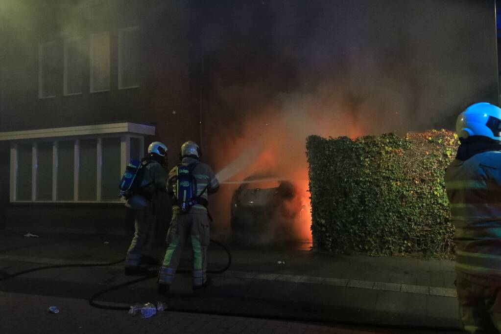 Auto in lichterlaaie onder carport van woning