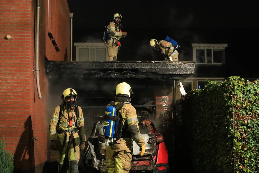 Auto in lichterlaaie onder carport van woning