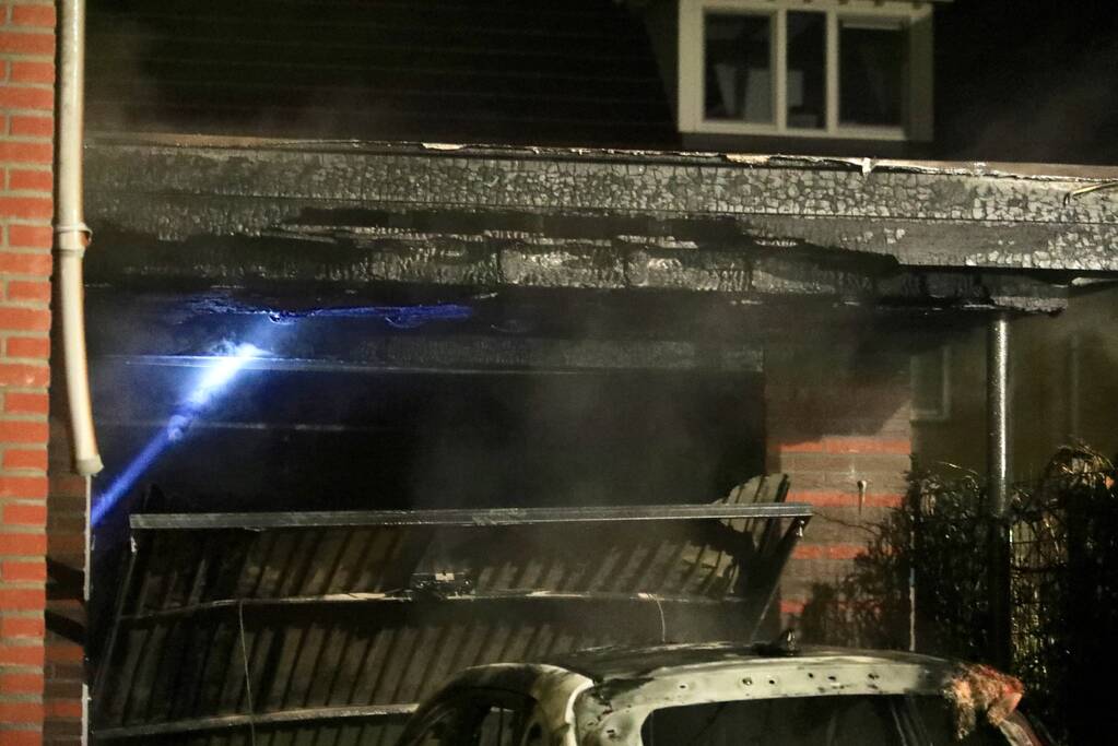 Auto in lichterlaaie onder carport van woning