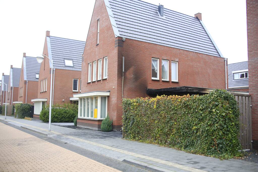Auto in lichterlaaie onder carport van woning