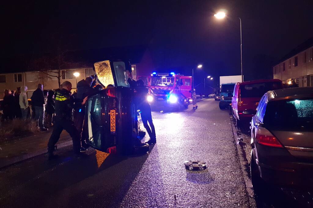 Bestuurster bekneld na auto op zijn kant