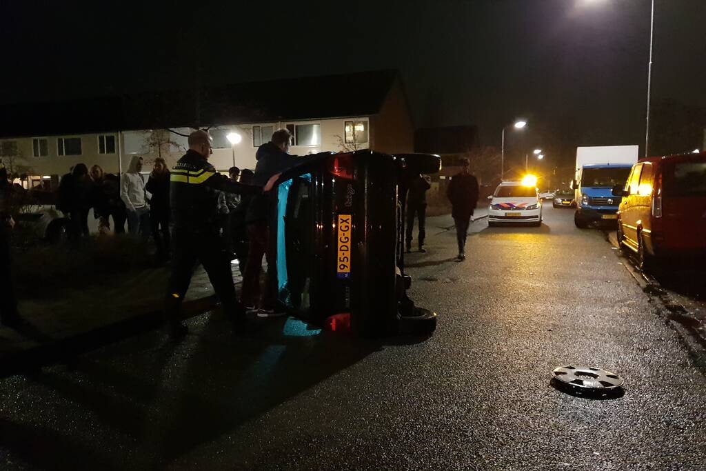 Bestuurster bekneld na auto op zijn kant