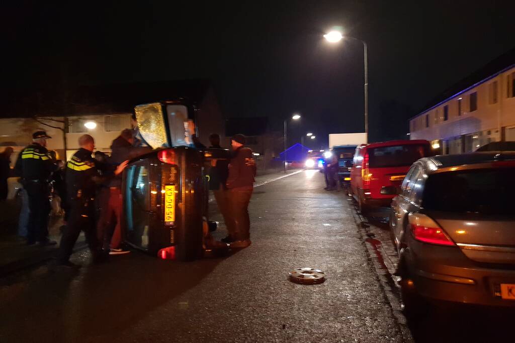 Bestuurster bekneld na auto op zijn kant