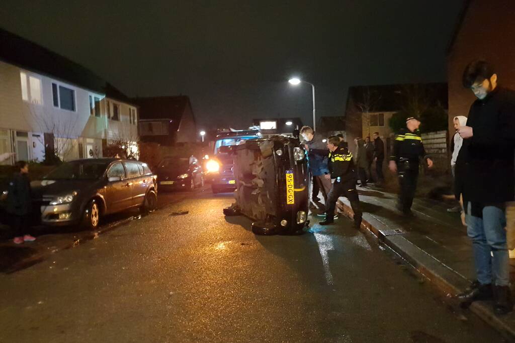 Bestuurster bekneld na auto op zijn kant