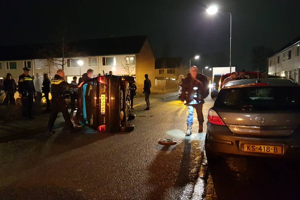 Bestuurster bekneld na auto op zijn kant