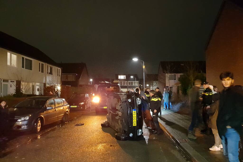 Bestuurster bekneld na auto op zijn kant