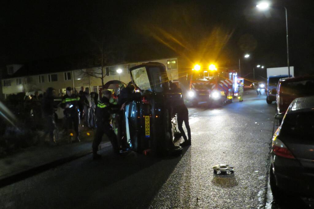 Bestuurster bekneld na auto op zijn kant